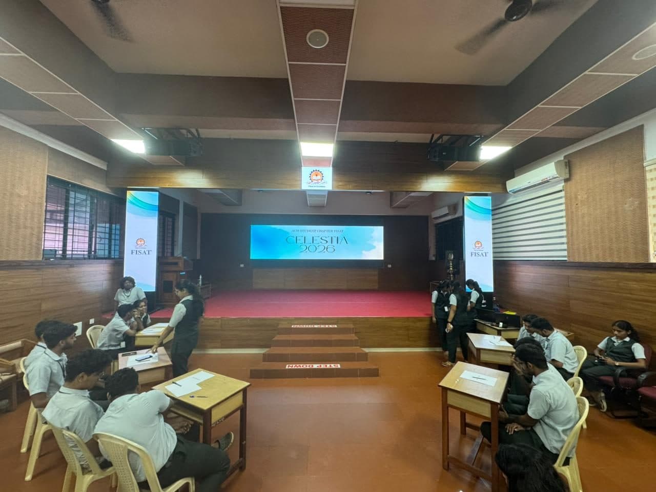 Wide view of the seminar hall set up for the Celestia 2026 quiz, with teams at desks on both sides of the stage
